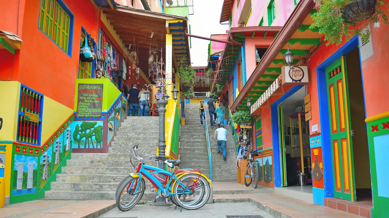 Escaleras y fachadas de colores con zócalos pintados y una bicicleta al pie